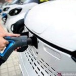 Ilustrasi - Seorang petugas menghubungkan kabel pengisi daya ke kendaraan listrik (EV) di stasiun pengisian daya. (ANTARA/REUTERS/Stringer/am)-1668056751
