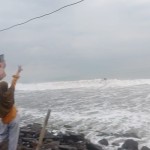 Wisatawan di pesisir Pantai Anyer menghadap arah Gunung Anak Krakatau di Perairan Selat Sunda yang tertutup kabut. ANTARA/Mansur-1672889717