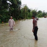 Petugas membantu warga melintas di jalan yang dilanda banjir di Kabupaten Simeulue, Jumat (1/9/2023). ANTARA/HO-Humas BPBD Simeulue-1693550677