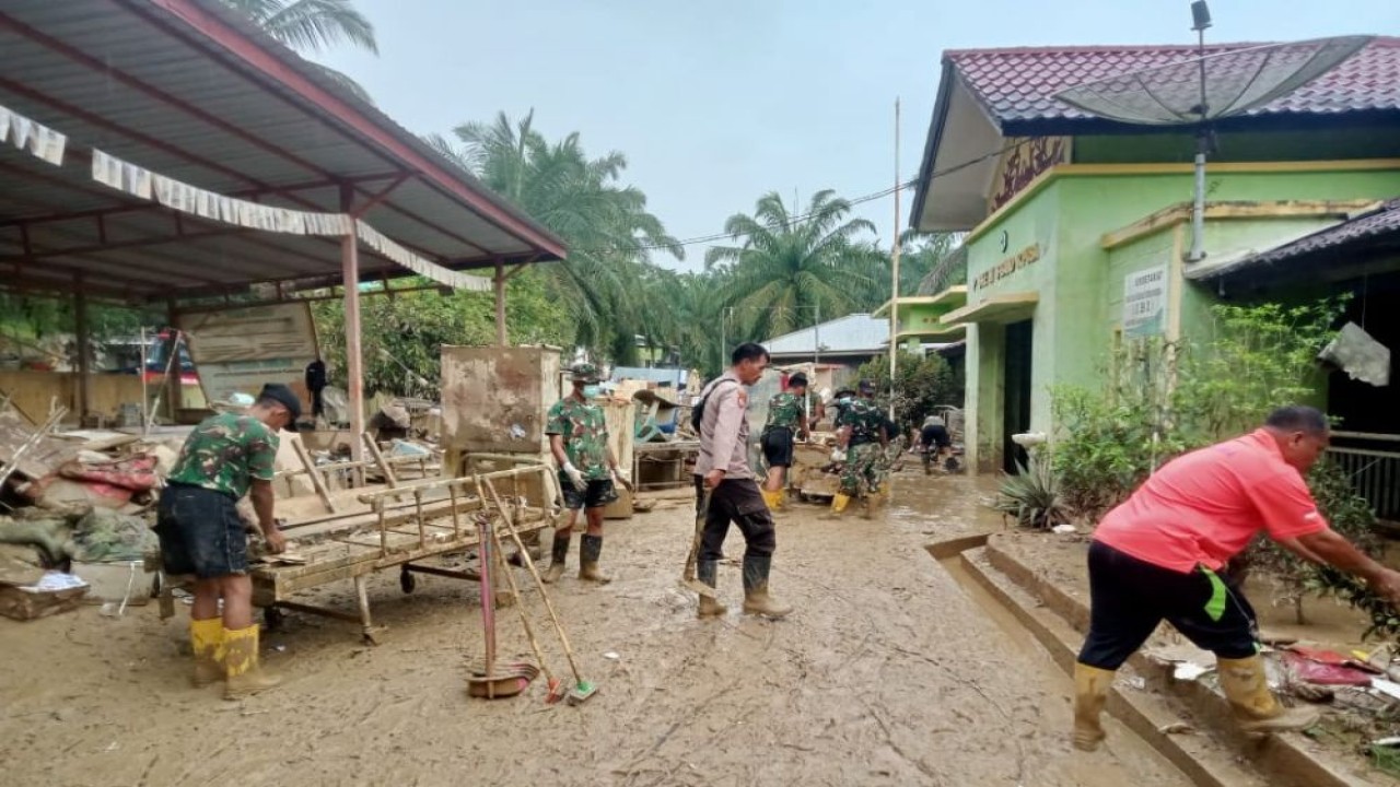 Para prajurit TNI dan BNPB bahu-membahu mengangkat lumpur, menyemprot ruang kelas dengan air bersih, serta membersihkan lingkungan sekolah. (Foto: Istimewa)