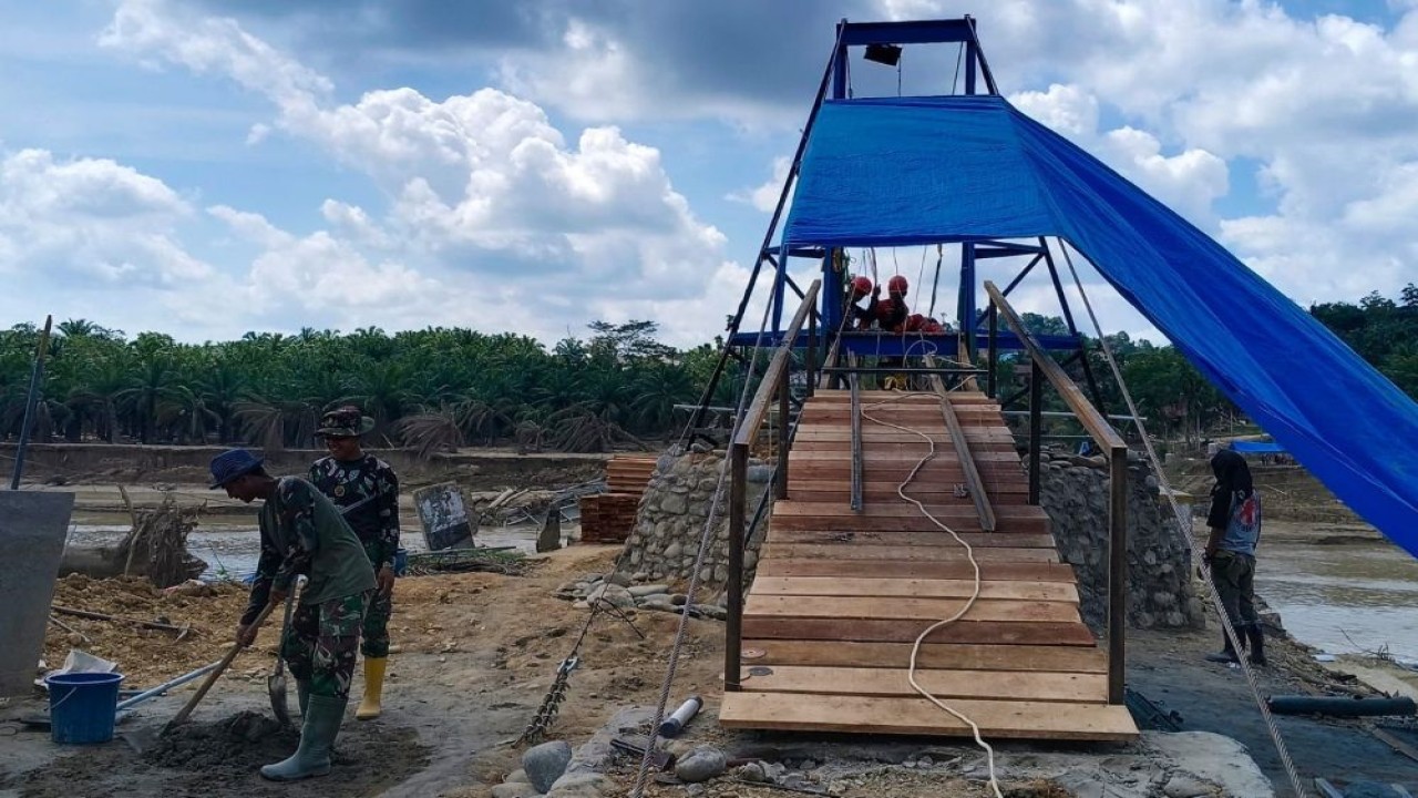 Personel TNI terus mempercepat pembangunan jembatan gantung agar akses bisa tersambung lagi. (Foto: Dok/Istimewa)