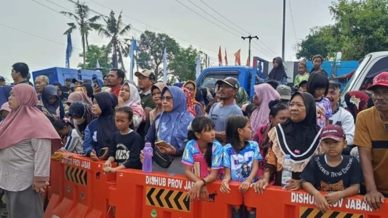 Warga menyaksikan kunjungan Presiden Republik Indonesia Prabowo Subianto di Karawang. ANTARA/Ali Khumaini (Antara)