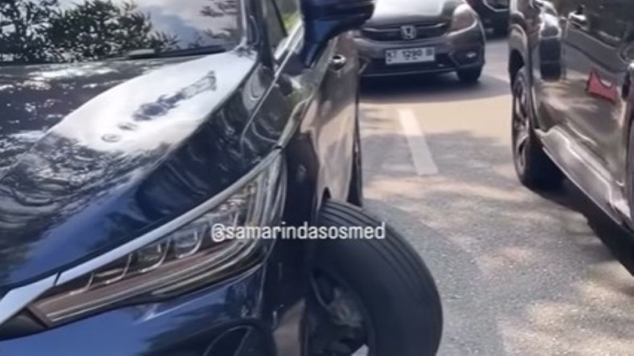 Sebuah mobil listrik berwarna biru tua terlihat mengalami patah as roda depan hingga menyebabkan kerusakan cukup parah. (Foto: Tangkapan layar)