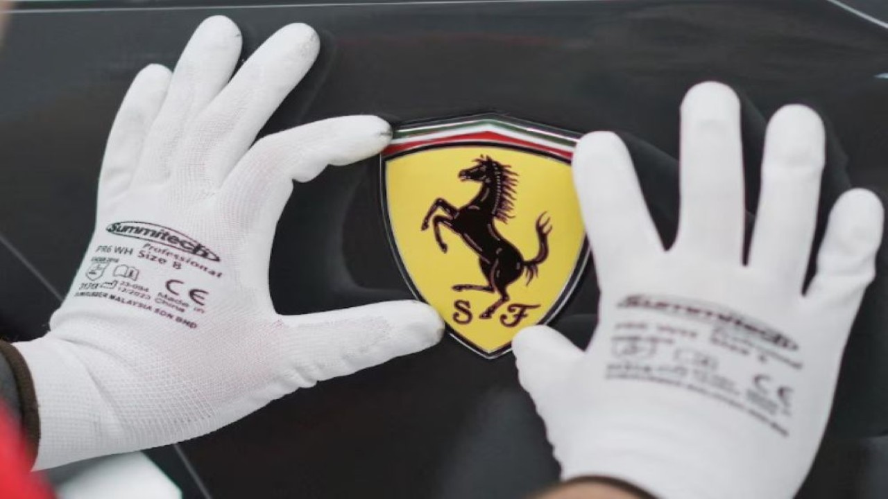 Logo Ferrari sedang dipasang pada mobil Ferrari di fasilitas "e-building" baru Ferrari, tempat produsen mobil sport mewah tersebut menguji lini produksi sebelum dimulainya produksi mobil yang diperkirakan pada awal tahun 2025, di Maranello, Italia, 21 Juni 2024. (Foto: Dok/Daniele Mascolo/Reuters)